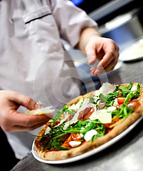 Dettagliato mano da cuoco panettiere bianco uniforme creazione una grande sfoglia circolare di pasta leggera sul la cucina 